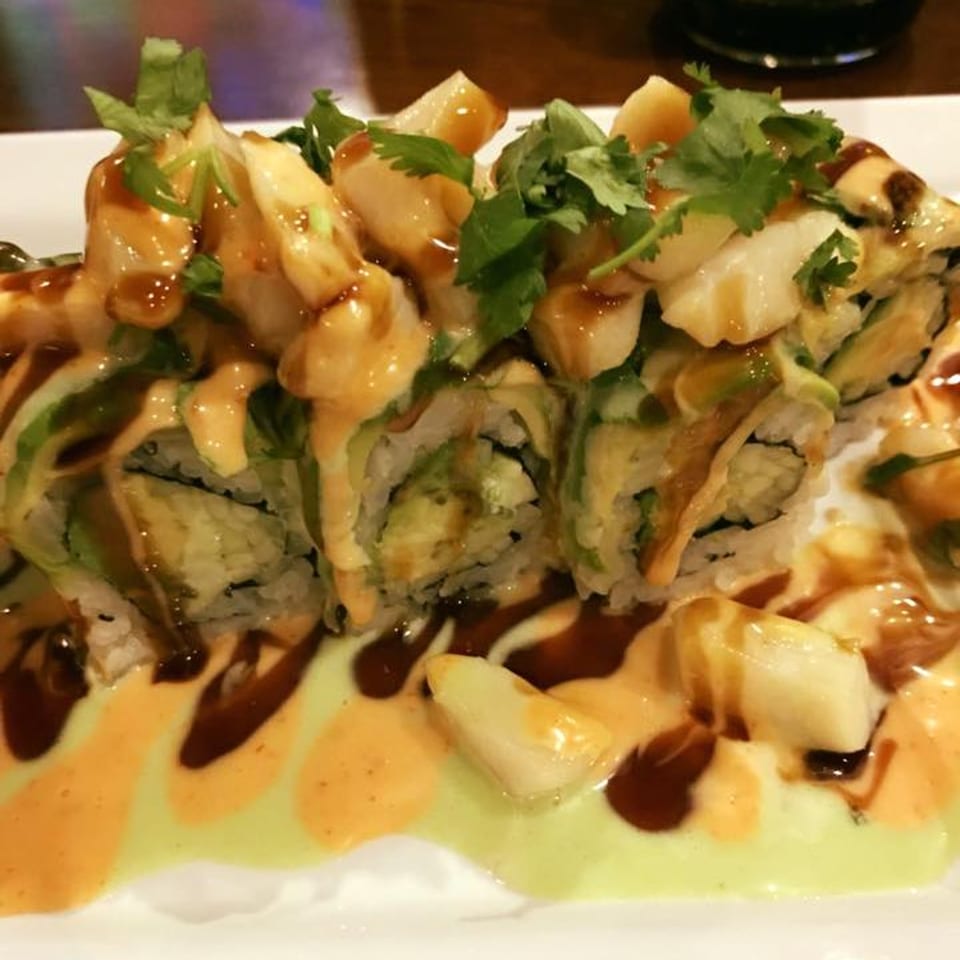 Kobe Hibachi Sushi and Bar's sushi roll with avocado, scallops, cilantro, and three sauces.